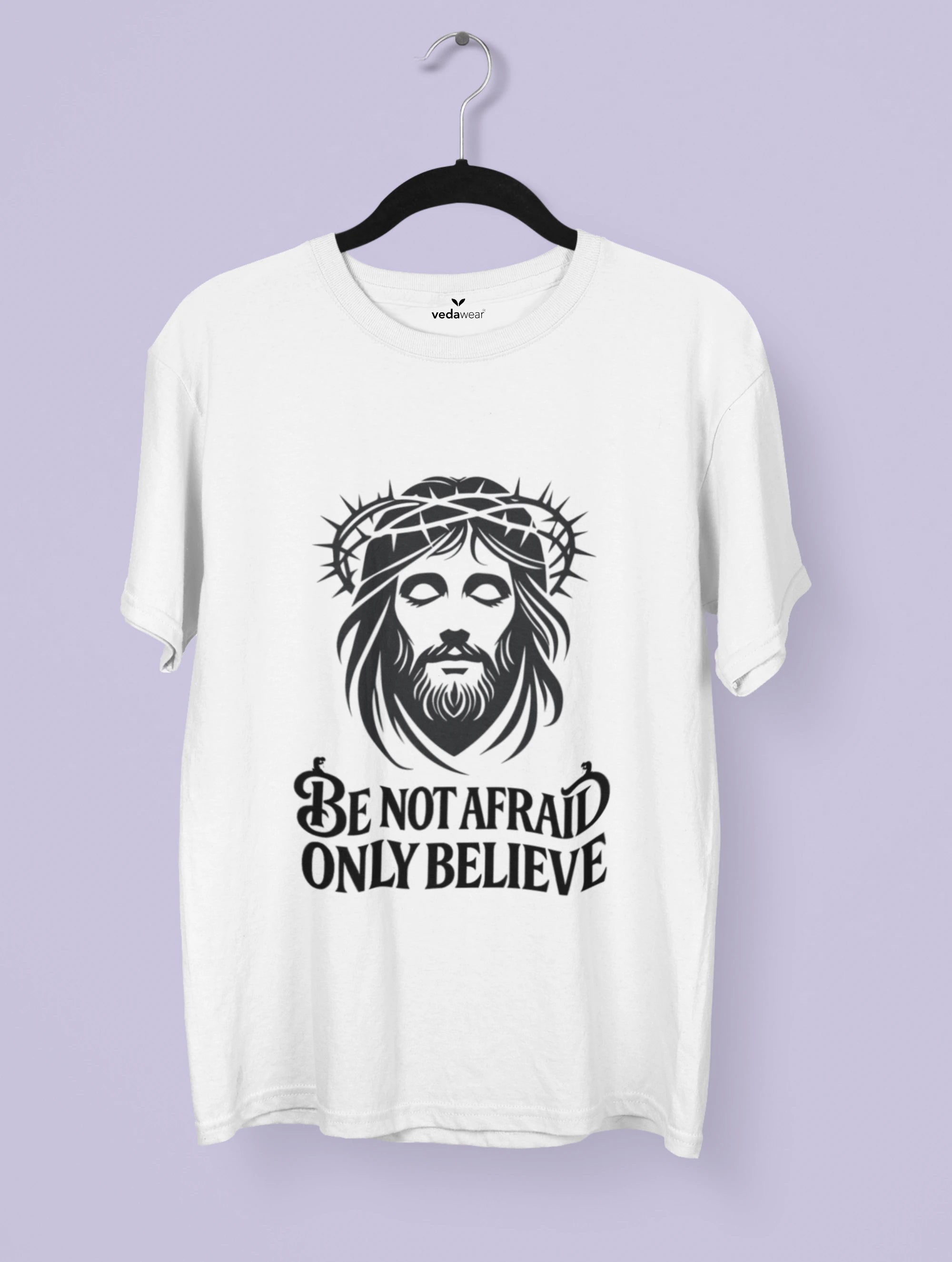 White t-shirt with a graphic ofJesus wearing a crown of thorns and text 'Be not afraid only believe' on a purple background.