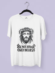 White t-shirt with a graphic ofJesus wearing a crown of thorns and text 'Be not afraid only believe' on a purple background.