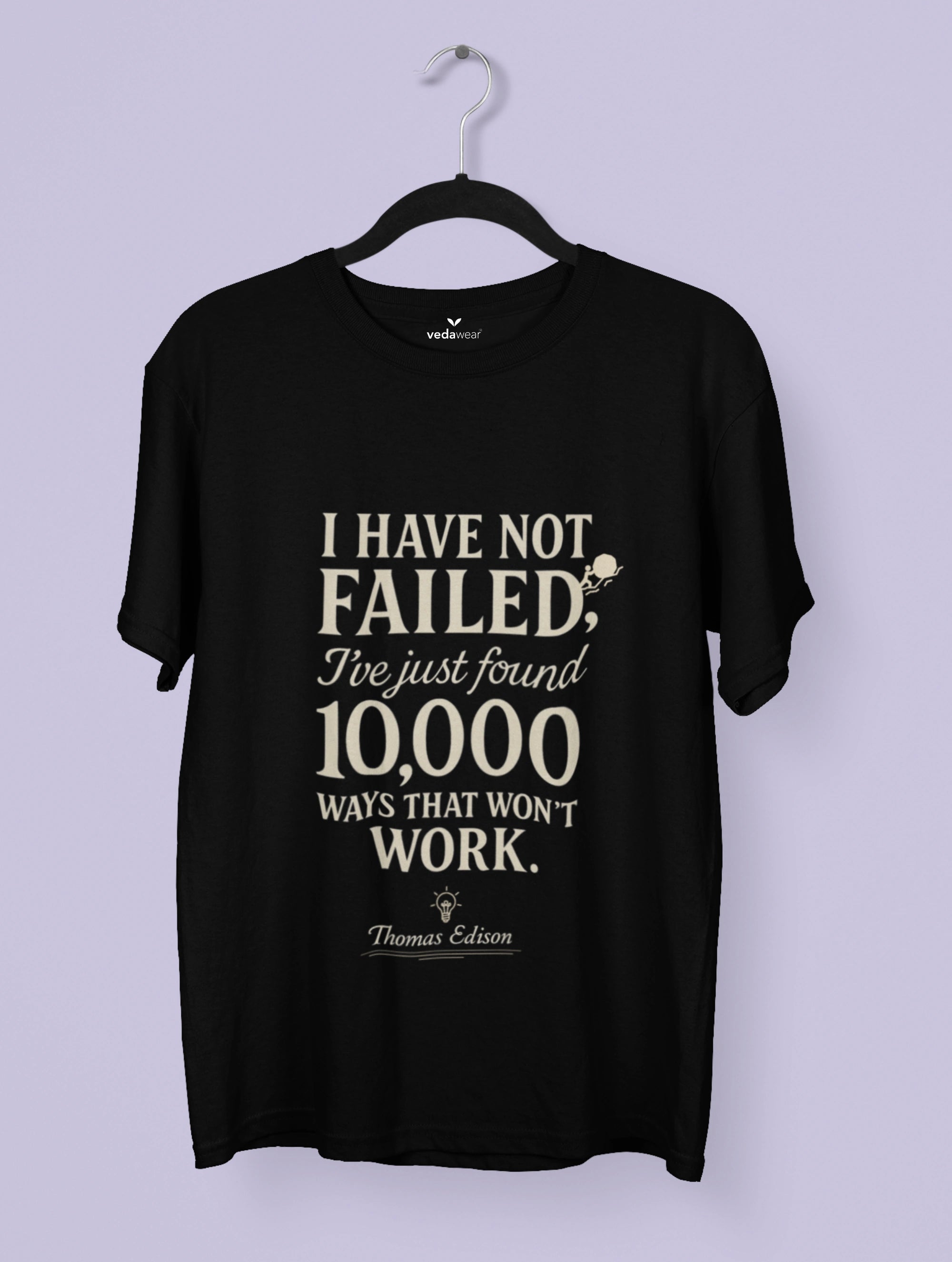 Black t-shirt with white text on a hanger against a light purple background