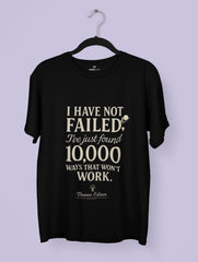 Black t-shirt with white text on a hanger against a light purple background
