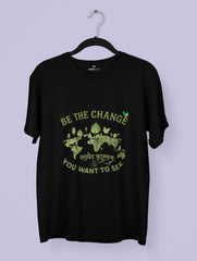 Black t-shirt with green graphic and text on a hanger against a light purple background