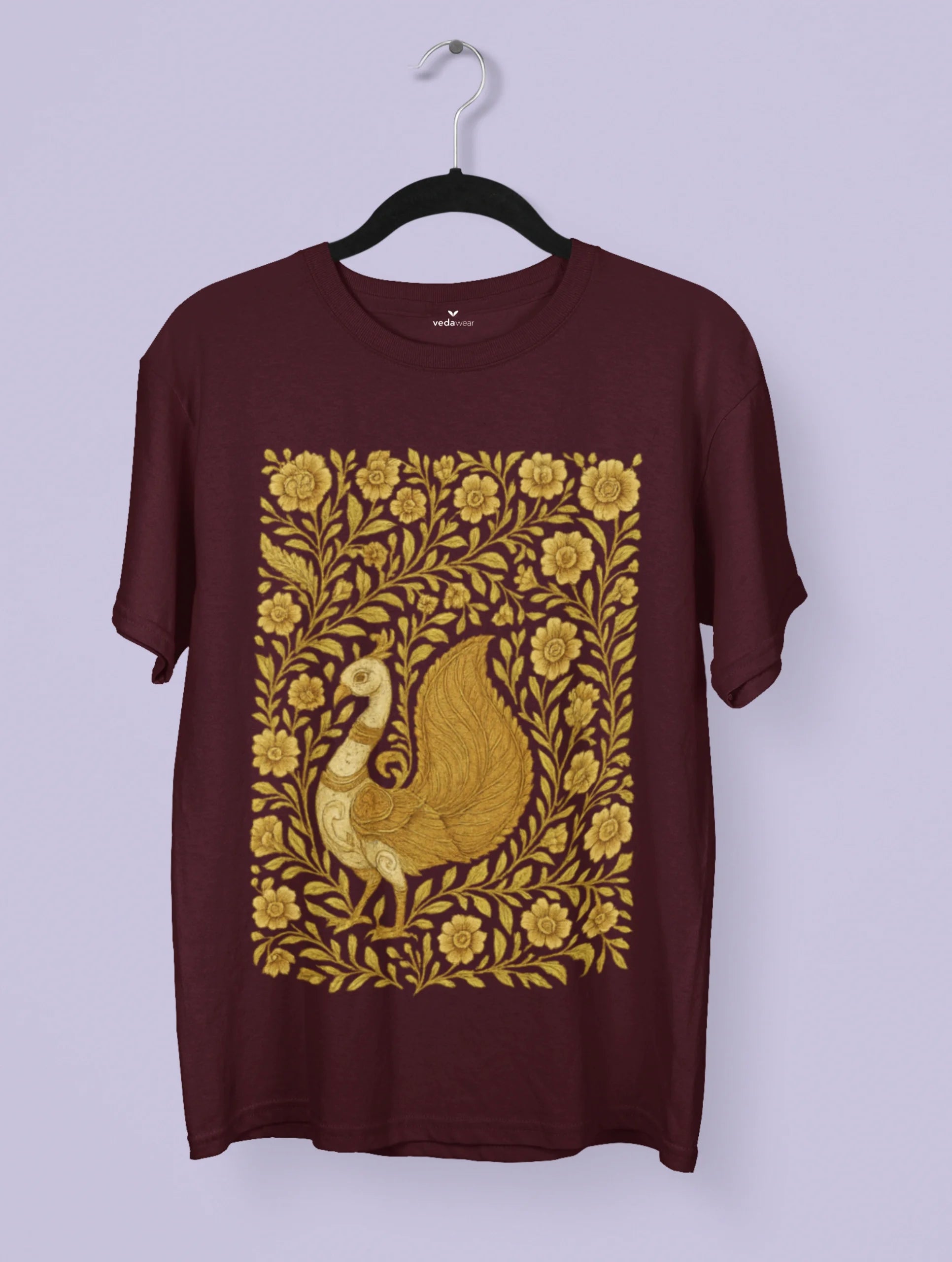 Golden Kalamkari peacock artwork on a black Vedawear premium tee, featuring intricate floral patterns and traditional Indian folk art detailing.
