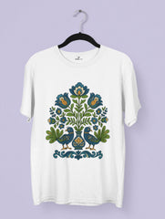 Hungarian folk art inspired premium cotton tee by Vedawear featuring bluebirds and floral motifs in indigo, green, and golden hues